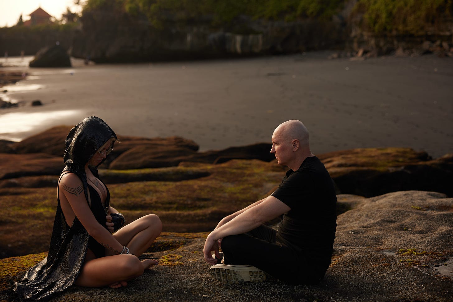 Energy healer transmitting pranic healing to student during chakra cleansing on beach
