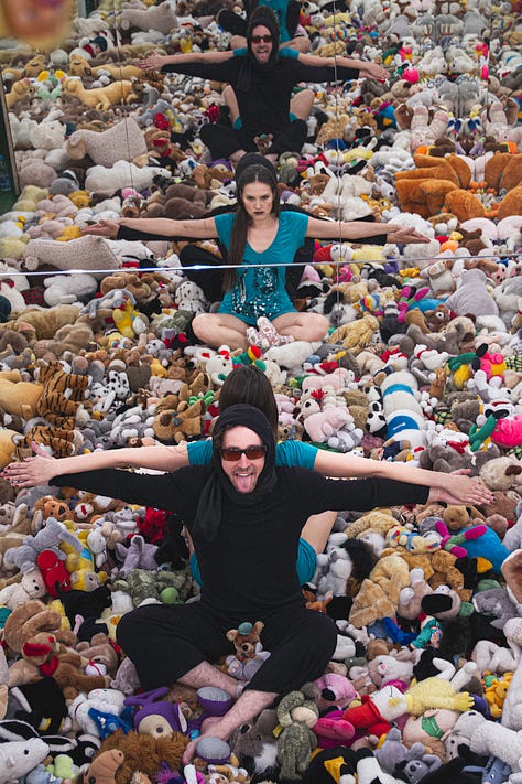 Playful performers with arms outstretched surrounded by supportive community